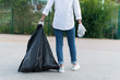 © Irvin Cardona - Person holding a trash bad and a plastic bottle