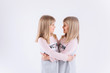 © Andreshkova Nastya - Happy adorable twin blodnie caucasian girls together having fun, hugging and playing. Smilling happy kids. Childhood, twins, friendship concept