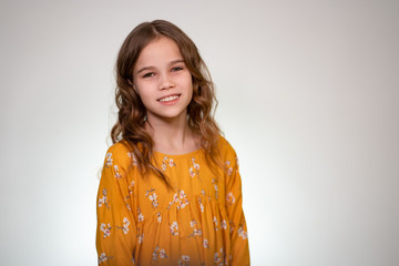 teenage girl smiles, looks camera white background