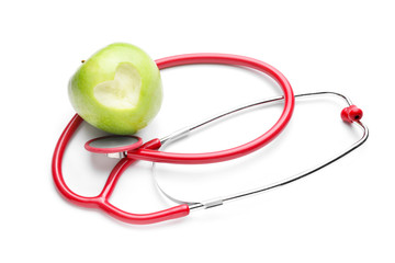 Fresh apple and stethoscope on white background