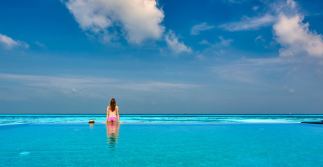 Canvas Print - Woman in infinity swimming pool at Maldives