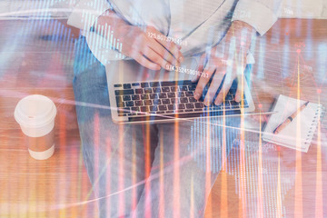 Forex graph with businessman working on computer in office on background. Concept of analysis. Double exposure.