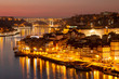 Barrio de La Ribeira de Oporto, río Duero y puente de la Arrábida iluminados al atardecer desde Vila Nova de Gaia (Portugal).