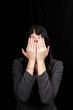 © Kateryna - See no evil concept. Portrait of a young scared woman covering eyes with hands, standing on dark studio background. Mixed girl close the eyes with palms while ignoring something