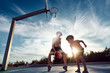 canvas print picture - Zwei coole jungs spielen Basketball beim Sonnenuntergang am Meer. 