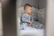 © Dusan Petkovic - Cute blonde little baby boy sitting in his crib and he is angry because nobody pays attention to him.