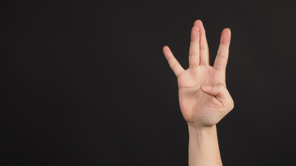 Hip-hop west coast hand sign on black background.