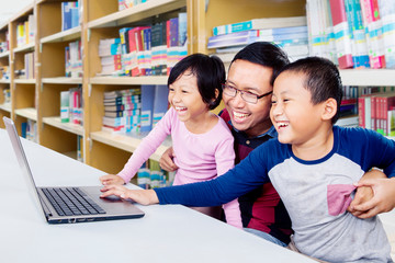 Wall Mural - Children laughing while being taught in a library