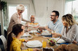 © Drazen - Happy extended family enjoying in lunch at dining table.