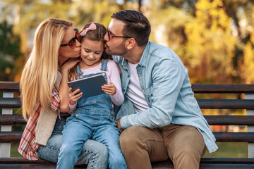 Wall Mural - Cheerful young family spending time together outdoors