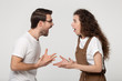 © fizkes - Aggressive stressed young couple arguing in front of each other.