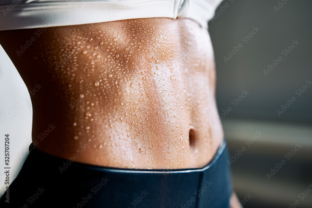 Close up of fit woman torso with sweat on skin after workout - obrazy, fototapety, plakaty 