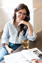 Sticker - Attractive young brunette woman studying in the cafe indoors