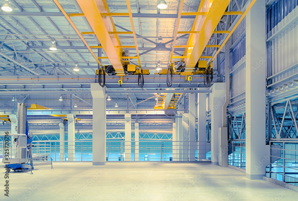 Concrete floor inside factory or warehouse building with empty space for industry background. Overhead crane or bridge crane include hoist lifting for transportation, manufacturing, and production. - obrazy, fototapety, plakaty 