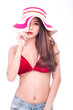 © Sasils Production - Cute asian woman in red bikini, summer hat and jeans isolated in white background. Touching hat, pulling hat to cover face. Sexy summer concept.