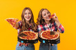 © Drobot Dean - Image of two young beautiful girls wearing plaid shirts eating pizza