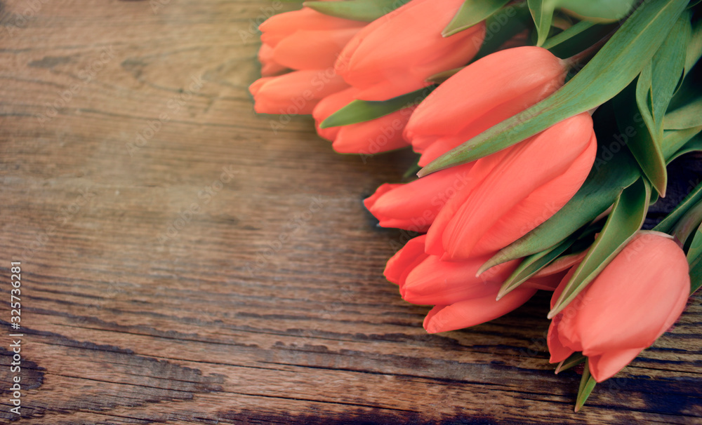 Close up red tulips bouquet on wooden background. Springtime greeting concept for Mothers day, Womens day or wedding. Copyspace. - obrazy, fototapety, plakaty 