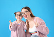 © New Africa - Young mother and little daughter with glasses on blue background
