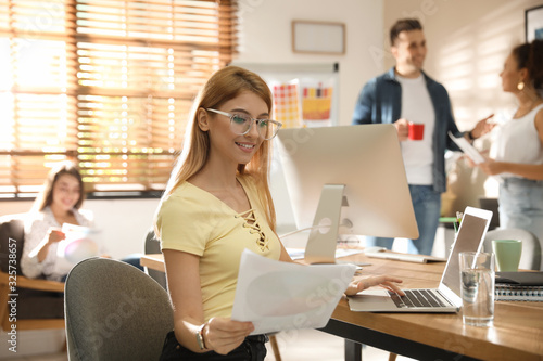 Portrait of happy female designer in office Poster Mural XXL