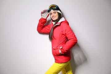 Wall Mural - Woman wearing stylish winter sport clothes on light grey background