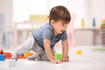 Wall Mural - Cute little child playing with toys on floor at home