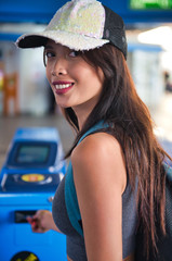 Wall Mural - Beautiful asian woman entering subway station inserting train ticket in the machine