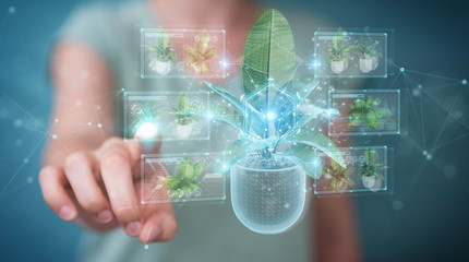 Fototapete - Woman holding and touching holographic projection of a plant with digital analysis 3D rendering