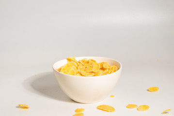 Corn flakes falling to the white bowl. Motion.