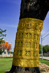 Wall Mural - The trees in the temple are wrapped in golden Thai pattern fabric.