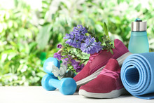 Composition With Spring Flowers And Sports Items On Blurred Green Background