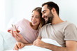 © Drobot Dean - Portrait of beautiful joyful couple smiling and using smartphone
