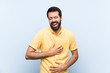 © luismolinero - Young man with beard over isolated blue background smiling a lot