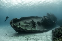 Divers Examining The Famous USS Kittiwake Submarine Wreck In The Grand Cayman Islands