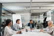 © LIGHTFIELD STUDIOS - young multicultural businesspeople sitting at desk in conference hall together with humanoid robot