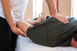 Male masseur therapist hands doing on strong male therapeutic body massage. Professional masseuse giving back massaging to a sportsman