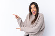 © luismolinero - Young brunette woman over isolated white background surprised and pointing side