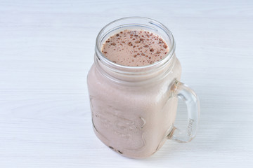 Cold base with refreshing chocolate drink on white wooden background