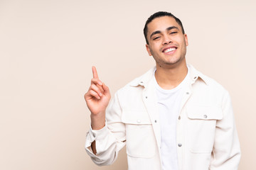 Asian handsome man over isolated background showing and lifting a finger in sign of the best