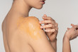 cropped view of girl applying sugar scrub on shoulder, isolated on grey