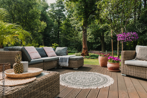 Fotografía Classy furniture on wooden terrace in green beautiful garden