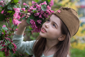 Wall Mural - Beautiful girl in uniform with flowers at the celebration of Victory Day in World War II. May 9 in Russia.