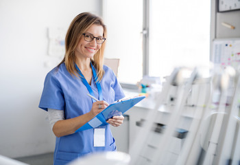 Wall Mural - A portrait of dental assistant in modern dental surgery, looking at camera.