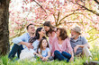 © Halfpoint - Three generation family sitting outside in spring nature.