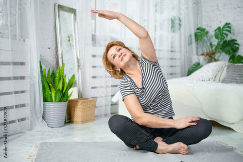 Fotografía Senior woman exercising while sitting in lotus position
