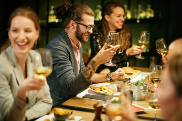 Sticker - Group of best friends sitting in restaurant, having dinner, drinking wine and having fun.