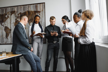 Portrait of a modern business team working at new project during meeting and looking at laptop. Multiracial business people working together.