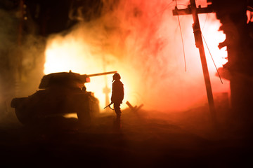 War Concept. Military silhouettes fighting scene on war fog sky background, World War Soldiers Silhouette Below Cloudy Skyline At night.