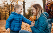 © Strelciuc - Cheerful caucasian mother playing with her kids while they are bringing autumn colorful leaves