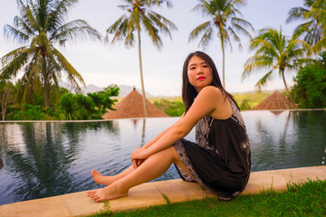 Wall Mural - young attractive and relaxed woman enjoying happy the beautiful view from tropical resort infinity pool in exotic luxury holiday and travel destination concept