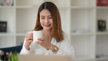 Wall Mural - Close up view of happy businesswomen take a break and holding coffee cup